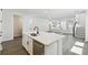 Open-concept kitchen features a center island with sink and stainless steel dishwasher, plus views to the living area at 3083 Voyager Ave, St Cloud, FL 34771