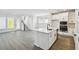 Open-concept kitchen featuring white cabinetry, stainless steel appliances, an island, and wood-look flooring at 3083 Voyager Ave, St Cloud, FL 34771