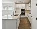 Modern kitchen with white cabinets, stainless appliances, quartz counters and wood-look flooring at 3083 Voyager Ave, St Cloud, FL 34771