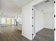 Bright and airy living room with wood-look flooring and fresh white walls, adjacent to foyer with decorative glass doors at 3083 Voyager Ave, St Cloud, FL 34771