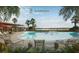 Resort-style pool with lounge chairs, umbrellas, and lakeside views at 3083 Voyager Ave, St Cloud, FL 34771