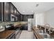 Modern kitchen with stainless steel appliances, dark wood cabinets, granite countertops, and tiled backsplash at 4706 Rockvale Dr, Kissimmee, FL 34758
