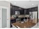 Modern kitchen featuring stainless steel appliances, granite countertops, and dark wood cabinets at 4706 Rockvale Dr, Kissimmee, FL 34758