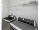 Laundry room featuring modern stainless steel washer and dryer, and overhead shelf at 4706 Rockvale Dr, Kissimmee, FL 34758