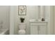 Neutral bathroom featuring a toilet, sink and cabinet with framed artwork on the wall at 5039 Barnet Dr, Davenport, FL 33837