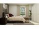 Contemporary bedroom showcasing a queen bed, bench, and neutral color palette with natural lighting at 5039 Barnet Dr, Davenport, FL 33837