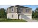 Charming two-story home featuring a manicured lawn, attached garage, and modern design elements at 5039 Barnet Dr, Davenport, FL 33837