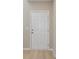 A classic white front door showcasing recessed panels, complemented by wood-look flooring and fresh paint at 1784 Frogmore Ave, Haines City, FL 33844