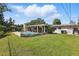 Large backyard boasts a pool, lush lawn, and covered patio, ideal for outdoor living and entertainment at 1005 Catalpa Ln, Orlando, FL 32806