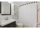 Cozy bathroom with a modern sink vanity, mirror, toilet and shower with stylish white curtain at 1005 Catalpa Ln, Orlando, FL 32806