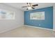 Simple bedroom with neutral paint, ceiling fan, windows offering natural light, and speckled tile at 1005 Catalpa Ln, Orlando, FL 32806
