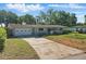 Charming single-story home featuring an attached garage and driveway with a landscaped front yard at 1005 Catalpa Ln, Orlando, FL 32806