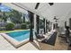 Covered patio with a beautiful pool featuring elegant curtains, stylish furniture, and inviting views at 1005 Catalpa Ln, Orlando, FL 32806
