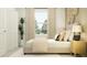 Bright bedroom with a large bed, neutral bedding, and a large window that brings in lots of natural light at 4220 Singing Mockingbird Blvd, Bartow, FL 33830