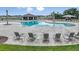 Community swimming pool with lounge chairs, tables, an outdoor kitchen and green grass all around at 4220 Singing Mockingbird Blvd, Bartow, FL 33830