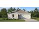 Charming one-story home with gray and white trim, a two-car garage, and beautifully landscaped front yard at 4220 Singing Mockingbird Blvd, Bartow, FL 33830