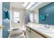 Bathroom featuring a tub with shower, vanity with sink, and a combined white and blue tiled design at 6125 Morningdale Ave, Lakeland, FL 33813