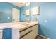 Bathroom with a vanity, white countertop, and blue walls, featuring a mirror and updated fixtures at 6125 Morningdale Ave, Lakeland, FL 33813