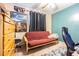 A bedroom with a red futon, desk, and black curtains, offering a flexible living space at 6125 Morningdale Ave, Lakeland, FL 33813