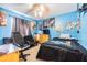 Bedroom showcasing blue walls, carpet, and decor with a ceiling fan and a black futon at 6125 Morningdale Ave, Lakeland, FL 33813