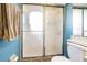 Bathroom featuring a shower with sliding glass doors, blue walls, and a towel bar with a tan towel at 6125 Morningdale Ave, Lakeland, FL 33813