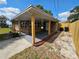 Spacious covered porch with brick exterior, wood posts, and concrete driveway at 1011 Old Lake Alfred Rd, Auburndale, FL 33823