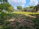 Spacious backyard with wooden fencing, offering shade and privacy at 1011 Old Lake Alfred Rd, Auburndale, FL 33823