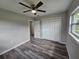 Light filled bedroom with wood-look flooring, a window and double door closet at 1011 Old Lake Alfred Rd, Auburndale, FL 33823