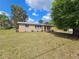 Charming brick home with a well-maintained lawn and mature trees under a sunny sky at 1011 Old Lake Alfred Rd, Auburndale, FL 33823