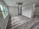 Open living room boasts fresh gray paint, recessed lights, and wood laminate floors at 1011 Old Lake Alfred Rd, Auburndale, FL 33823