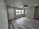 Bright living room features a ceiling fan, wood floors, and front door entrance at 1011 Old Lake Alfred Rd, Auburndale, FL 33823