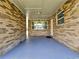 A covered patio features brick walls, ceiling lights and blue painted floor at 1011 Old Lake Alfred Rd, Auburndale, FL 33823