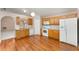 Eat-in kitchen featuring wood floors and white appliances at 2076 Whispering Trails Blvd, Winter Haven, FL 33884