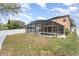 Backyard with screen-enclosed pool and attached hot tub, on a partly cloudy day at 265 Elderberry Dr, Davenport, FL 33897