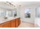 Bathroom featuring double sinks, a large mirror, and a walk-in shower at 265 Elderberry Dr, Davenport, FL 33897