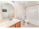 Bright bathroom featuring a shower-tub combo and a large mirror above the sink at 265 Elderberry Dr, Davenport, FL 33897