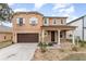 Two-story home with a well-maintained yard, covered entrance, and a two-car garage at 265 Elderberry Dr, Davenport, FL 33897