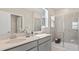 Bathroom featuring double vanity, grey cabinets, white countertop, glass shower door, and tile surround at 2938 Haze Rd, Clermont, FL 34714