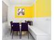 Bright dining room featuring a built-in bench, stylish purple chairs, and a vibrant yellow accent wall with modern artwork at 5645 Meditation Dr, Clermont, FL 34714