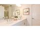 A bright bathroom featuring double sinks, white cabinets and fixtures and tile flooring at 1920 Rosewood Cir, Lakeland, FL 33810