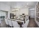 Open dining area with modern lighting, view of the white kitchen, and seating for eight at 1018 Brimstone Cir, Winter Haven, FL 33884