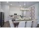 Bright dining area with modern chandelier, table with 6 chairs, and seamless flow into a white kitchen at 1018 Brimstone Cir, Winter Haven, FL 33884