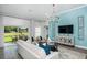 Inviting living room featuring light blue accent wall, contemporary decor, and sliding glass doors to outdoor patio at 1018 Brimstone Cir, Winter Haven, FL 33884