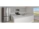 Modern kitchen with stainless steel appliances, gray cabinets, and a large quartz island at 1018 Foreshore Ln, Haines City, FL 33844