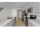 Open kitchen with stainless steel appliances, white quartz countertops, and gray shaker cabinets at 1018 Foreshore Ln, Haines City, FL 33844