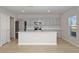 Modern kitchen with stainless steel appliances, gray cabinets, and a large center island at 1018 Foreshore Ln, Haines City, FL 33844