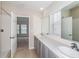 Bright bathroom with dual sinks, quartz countertop, walk-in shower, and natural light from a window at 1026 Foreshore Ln, Haines City, FL 33844