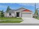 Charming single-story home featuring a two-car garage, well-manicured lawn and simple, clean landscaping at 1026 Foreshore Ln, Haines City, FL 33844