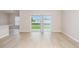 Bright living room with wood floors, a sliding glass door with blinds to a covered patio and an adjacent kitchen at 1026 Foreshore Ln, Haines City, FL 33844