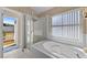 This bathroom includes a garden tub and glass shower with views of the outdoors at 112 Thorne Meadow Pass, Davenport, FL 33897